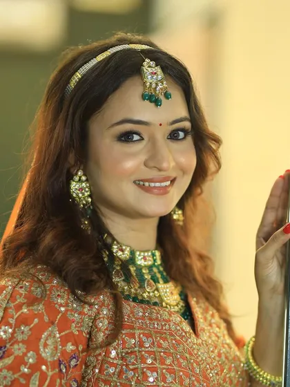 Elegance at its best. A beautiful portrait of the bride in her orange and green lehenga.