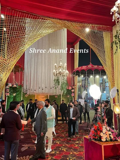 A view from inside the entrance, showing guests arriving and mingling under the grand arched structure with beautiful lighting.