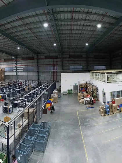 A wide-angle view of the warehouse, showing the packaging and processing area. This shot provides a comprehensive look at the different functional zones within the large industrial space.