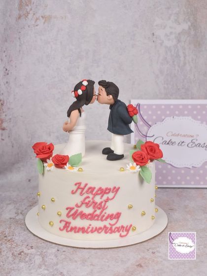 The full view of the first anniversary cake, complete with buttercream lettering and delicate floral details.