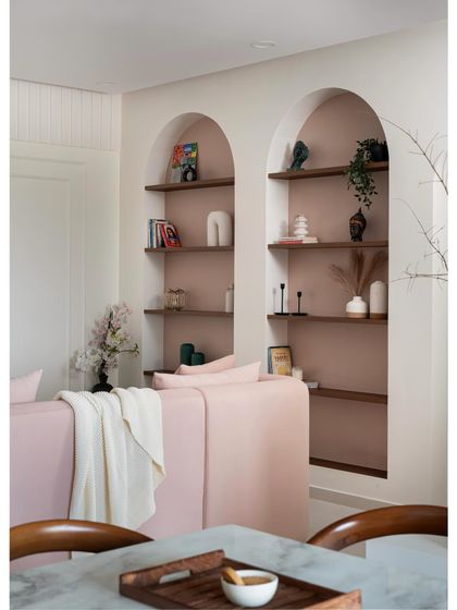 A view from the dining area into the living room of "Casa Curva," highlighting the seamless flow between the spaces and the consistent use of soft, curved forms.