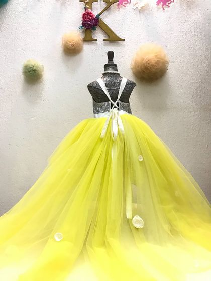 It’s not just a gown, it’s a dream. This stunning yellow tulle gown features a dramatic, flowing trail that makes a statement with every step. Perfect for a grand entrance at a wedding or a milestone birthday party.