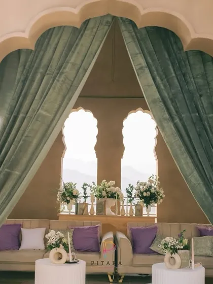 A view of the lounge through the elegant archway, framed by soft green drapes. The setup was designed to feel like a private, luxurious retreat high above the city.