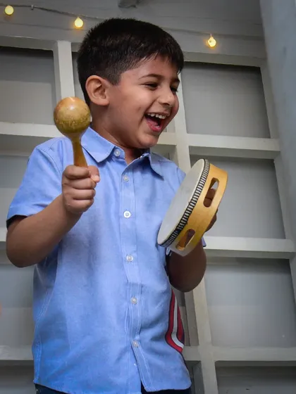 Making some joyful noise with a tambourine and maraca. Music is always part of the fun.