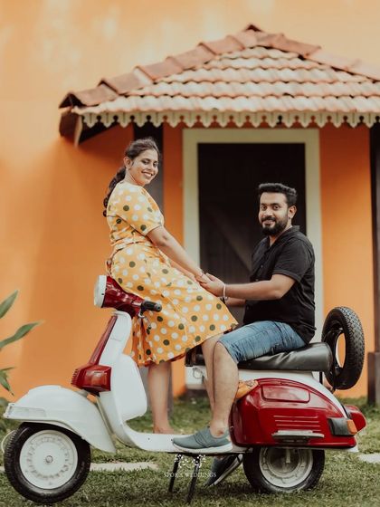 The couple posing with a vintage scooter, a fun and quirky element for their pre-wedding photos.