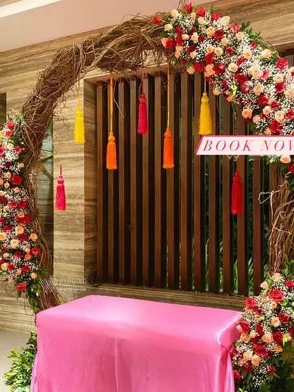 A perfect blend of rustic and vibrant, this arch uses a natural twig frame adorned with bright flowers and playful tassels.