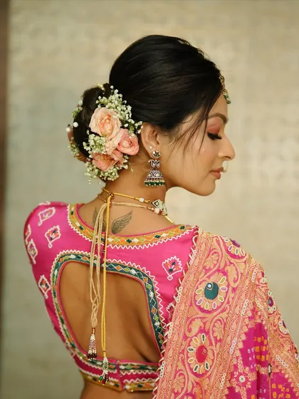 A beautiful floral bun that complements the bride's pink Gujarati-style saree. The soft pink roses add a touch of grace and elegance.