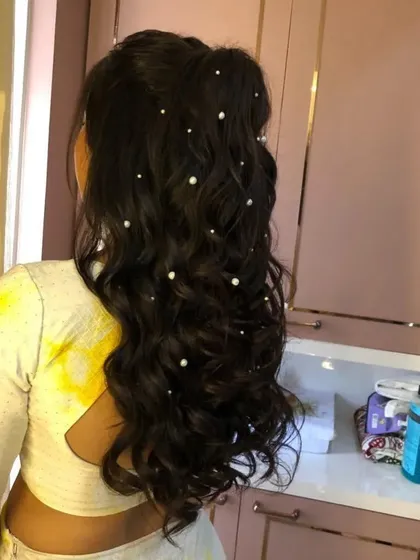 A side view of the half-up hairstyle with pearls, showing how it keeps the hair off the face while still looking soft and romantic.