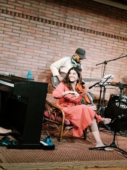 A candid shot of the REFUGE quartet during their performance, with violinist Apoorva Krishna smiling, capturing a moment of joy and connection on stage.