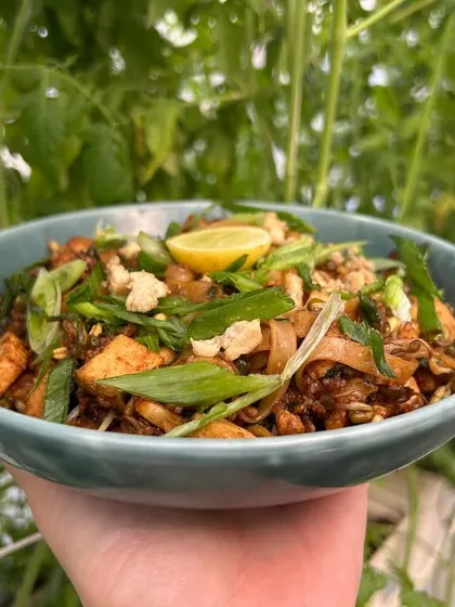 Serving happiness, one dish at a time. This vibrant Pad Thai is loaded with fresh vegetables, tofu, and noodles, all tossed in a savory and tangy sauce.