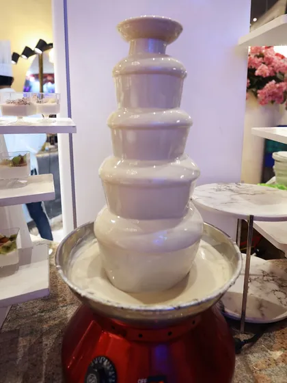 A white chocolate fountain, offering a sweet and creamy alternative for dipping fruits and marshmallows.