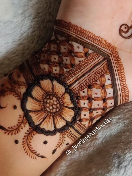 A close-up of the floral cuff on the wrist, showing the detailed line work and shading.