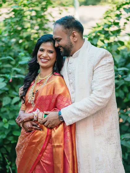 A warm embrace in a lush garden setting. This portrait is all about closeness and affection, highlighting the couple's joy on their special day.