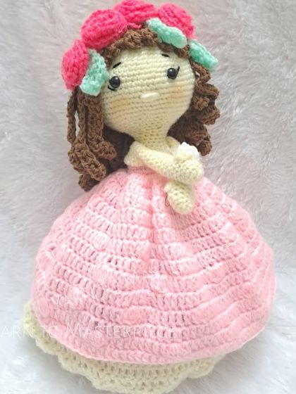 A full view of one of my reversible dolls, featuring a pink dress and a crown of colorful roses. Every detail, from her hair to her dress, is lovingly stitched by hand.