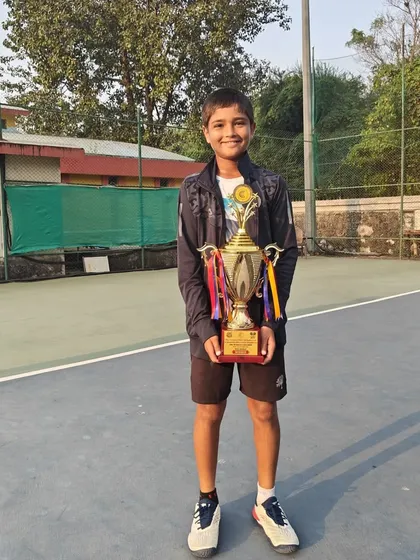 Aarav Chhallani proudly holding his winner's trophy from the U-14 National Series doubles event.