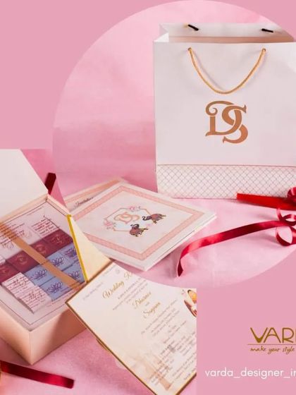 A complete gifting set featuring a custom-monogrammed paper bag, a box of assorted chocolates, and a suite of matching invitation cards. This shows how I can create a cohesive brand for your entire event.