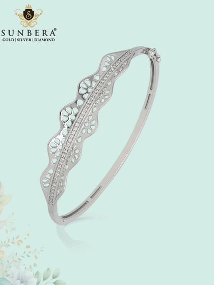 An elegant silver kada bracelet with a delicate, wavy design featuring floral enamel work. This piece speaks of grace and sophistication.