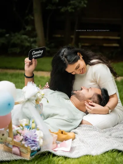 A sweet and playful picnic setup is a wonderful way to announce your joy. This maternity shoot uses props like a "Coming Soon" sign to add a personal and fun touch.