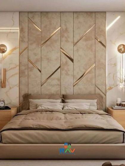 This luxurious bedroom design features a stunning accent wall with marble-finish panels and geometric gold inlays. The wall-mounted sconces add a touch of hotel-like elegance.