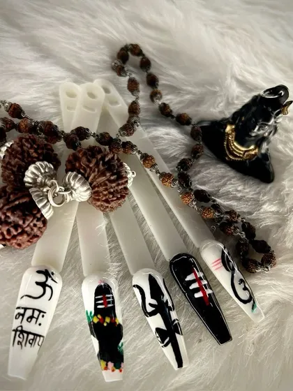 Artistry knows no bounds. This intricate nail art set is inspired by the divine power of Mahadev, featuring detailed symbols like the Trishul and Om script, showcasing our artists' precision.