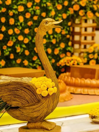 A beautiful golden swan statue, elegantly incorporated into the floral decor of the Haldi ceremony.