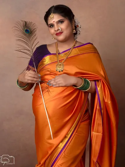 A solo portrait with a peacock feather, a nod to Lord Krishna and a symbol of grace and beauty.