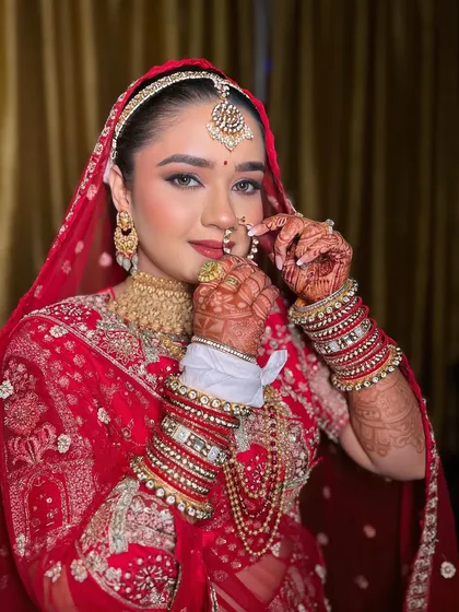 Adjusting the nath is a classic bridal moment. The makeup is set to perfection to withstand all the movements and emotions of the day.