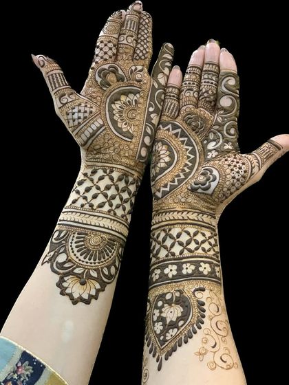 A gorgeous bridal design against a black background, which makes the henna details pop. The patterns are a mix of traditional Indian and Arabic styles.