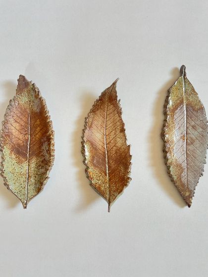 A trio of long, elegant leaves, immortalized in ceramic. These can be hung on the wall to create a beautiful, natural art installation.