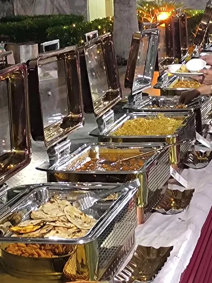 A classic buffet line featuring a variety of Indian dishes in stainless steel chafing dishes. This setup is perfect for ensuring food remains hot and fresh throughout an event.