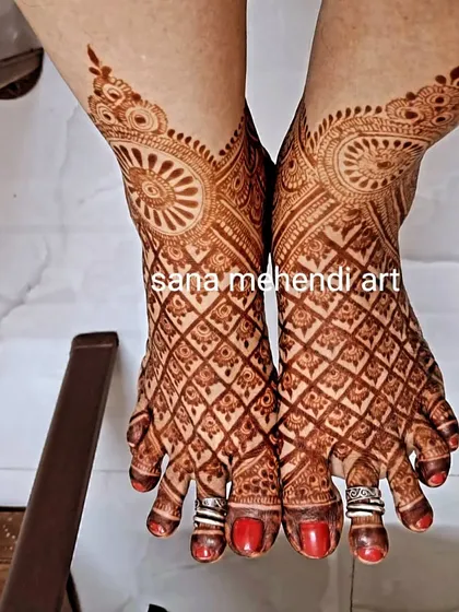 A complete bridal look includes beautifully adorned feet. This intricate foot mehendi features detailed jaali work and traditional patterns, ensuring you are decorated from head to toe on your big day.