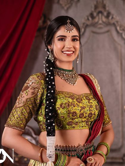 A happy, smiling shot of the non-bridal look. The messy pearl-adorned braid and glowing skin are key features.
