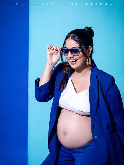 A confident and happy portrait, showing off the baby bump with a cool, contemporary vibe.