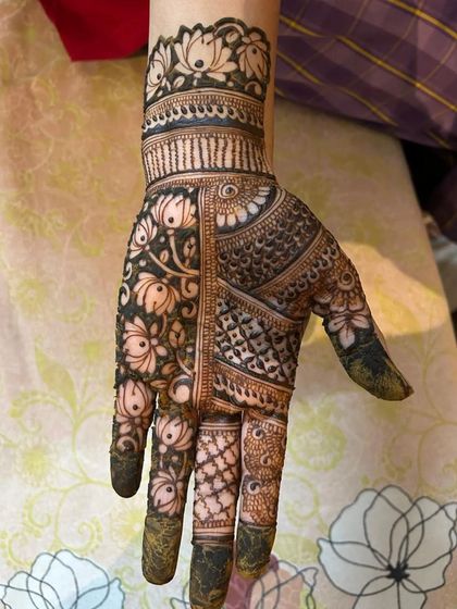 A full-hand design with a dark, rich stain. The contrast between the bold floral pattern and the intricate fillers is a key technique we practice.