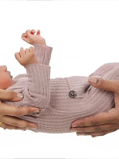 There's nothing like the feeling of holding your new baby. This classic pose highlights the connection and love of new parents, creating a timeless family portrait that focuses on their hands supporting their little one.