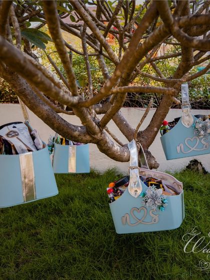 Thoughtful details make all the difference. We arranged for these personalized welcome hampers for guests, hanging them from tree branches for a whimsical touch at the Mehendi.