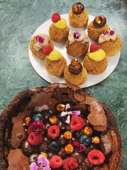 A beautiful pairing of my flourless chocolate cake and assorted choux pastries. The combination of rich chocolate and light, creamy choux is a customer favorite.