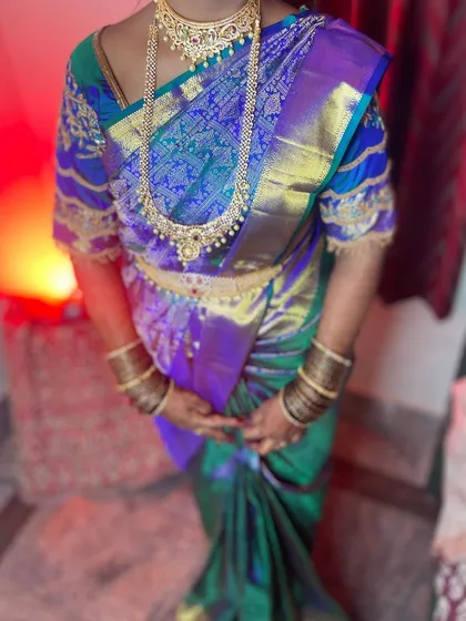 A close-up of the torso, showing how the pleats are neatly tucked and the pallu is arranged to display the heavy zari work.