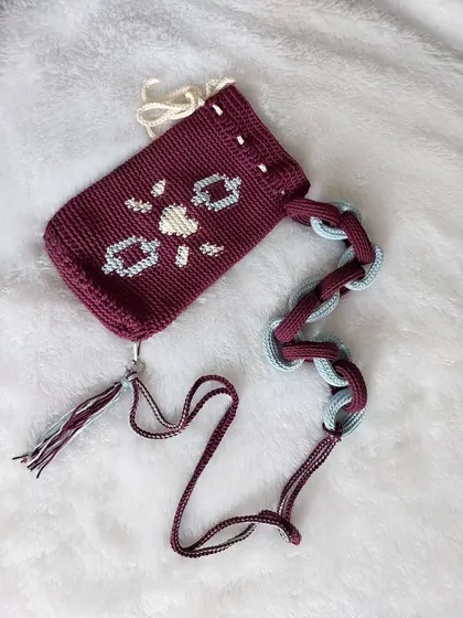 A flat-lay of the Elara Bag, highlighting the tapestry pattern and the combination of the chain strap and cord strap.