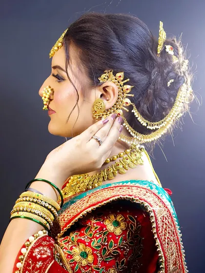 A detailed view of the traditional ear cuffs (kaan vel) and the intricate hairstyle, which are key elements of an authentic Maharashtrian bridal look.