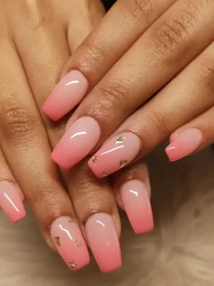A warm pink ombre on coffin-shaped nails, fading from a light base to a brighter pink tip, with delicate gold foil accents.