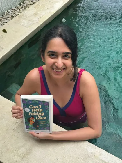 Taking my book for a swim. Here I am with an advance copy of *Can't Help Faking in Love* by the pool, trying not to drop it in the water.