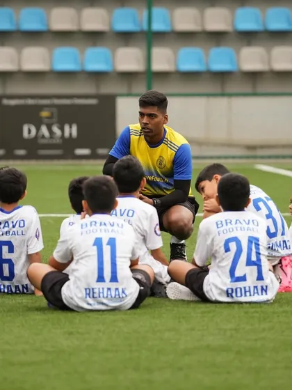 Head Coach Siddhesh Tambekar, having earned his AFC B Licence, kneels down to talk to his youngest players. This image celebrates a coach who is a mentor, friend, and guide to hundreds of children.