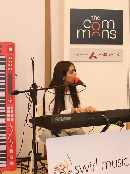 A student performs a song on the keyboard while singing at our MuSo event. We teach students how to combine skills, like playing an instrument and singing simultaneously.