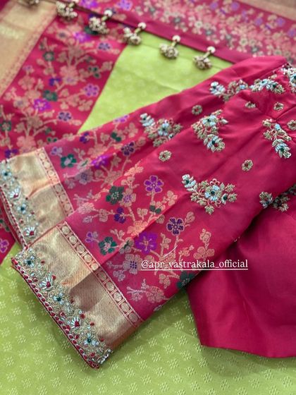 A pink blouse with multi-color floral embroidery on the sleeves.