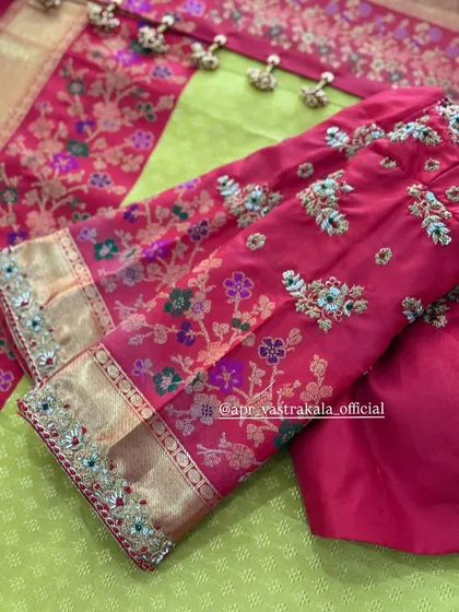 Detailed floral embroidery on the sleeves of a pink blouse, paired with a lime green saree for a fresh and festive look.