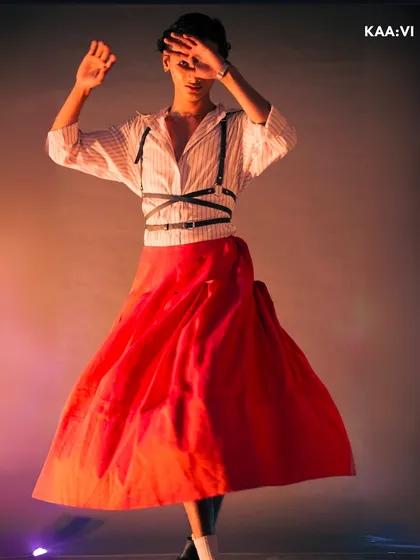 This is from a creative shoot where I explored androgynous styling. By pairing a voluminous red skirt with a classic striped shirt and a modern leather harness, I aimed to create a look that blends retro and contemporary elements in a bold, unconventional way.
