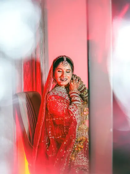 A candid moment of the bride adjusting her earring, caught through a creative foreground blur. This artistic technique adds depth and a sense of intimacy to the portrait.
