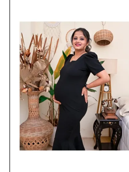 A confident and happy portrait of a mom-to-be in our Boho-themed studio. The black dress creates a lovely contrast with the natural textures of the wicker, dried plants, and vintage-style telephone.