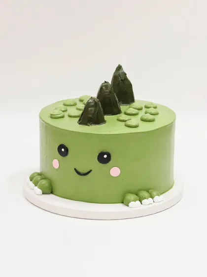 A straight-on view of the cute dino cake.